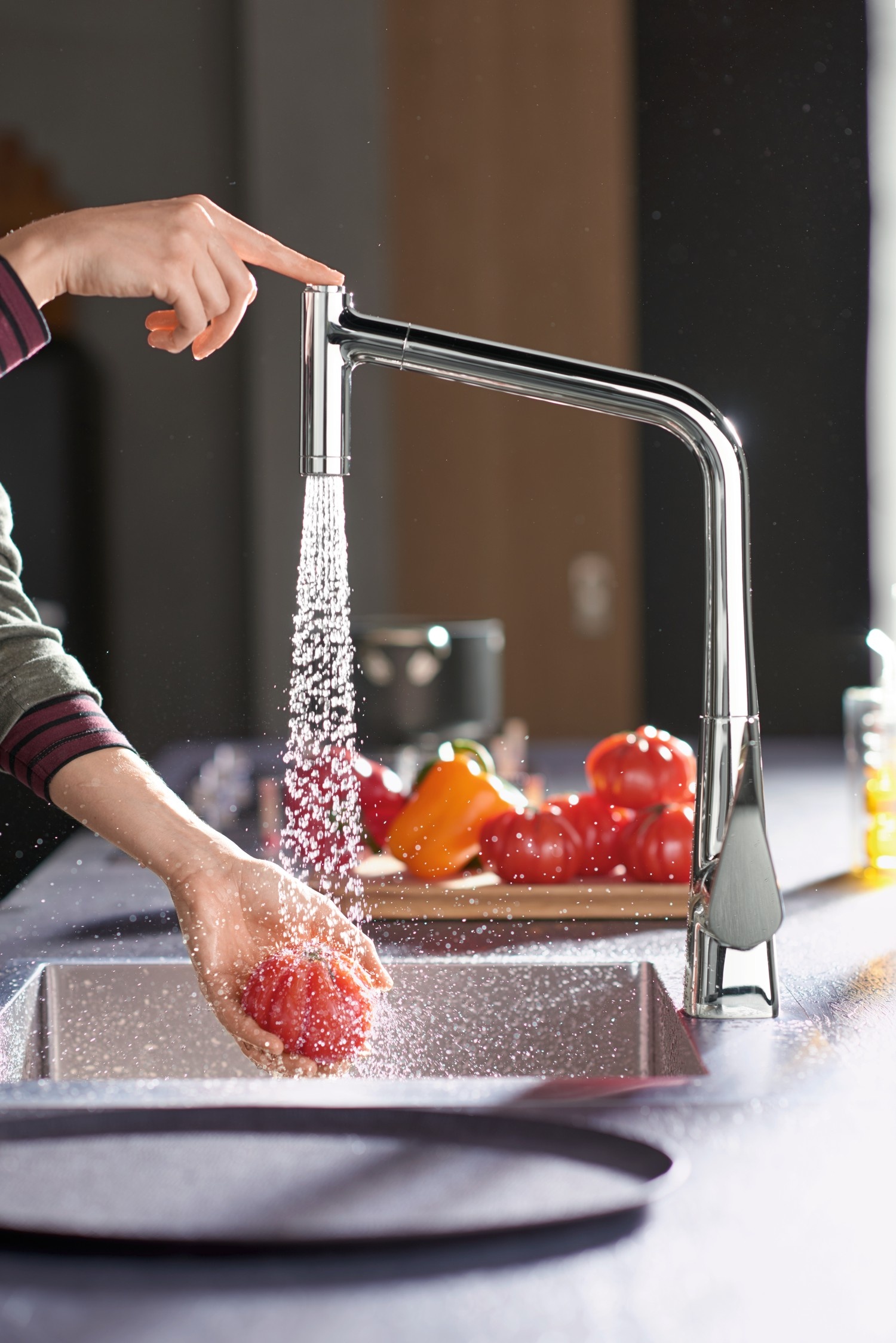 Nowoczesna bateria nad szarym zlewem i papryką fot. Hansgrohe
