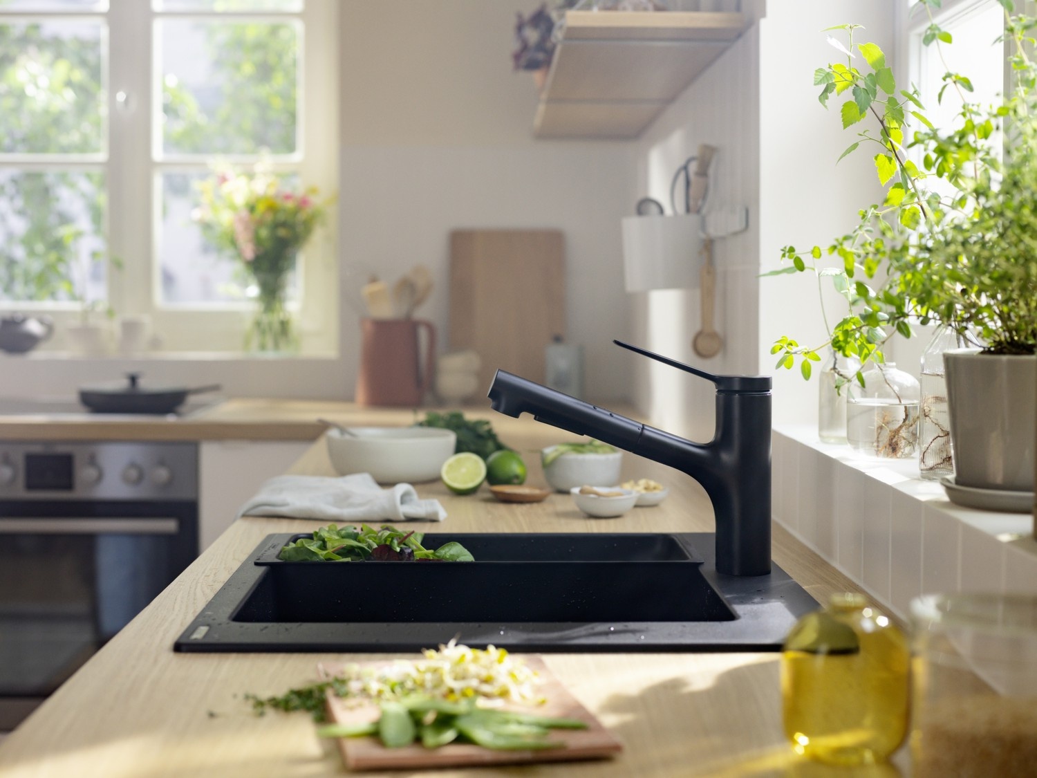 Czarna bateria przy nowoczesnym zlewie pod oknem fot. Hansgrohe