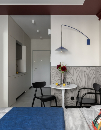 Zaskakujący sufit i ukryta kuchnia. To 20-metrowe wnętrze robi wrażenie! Bordowa łazienka gra tu gł&oacute;wną rolę